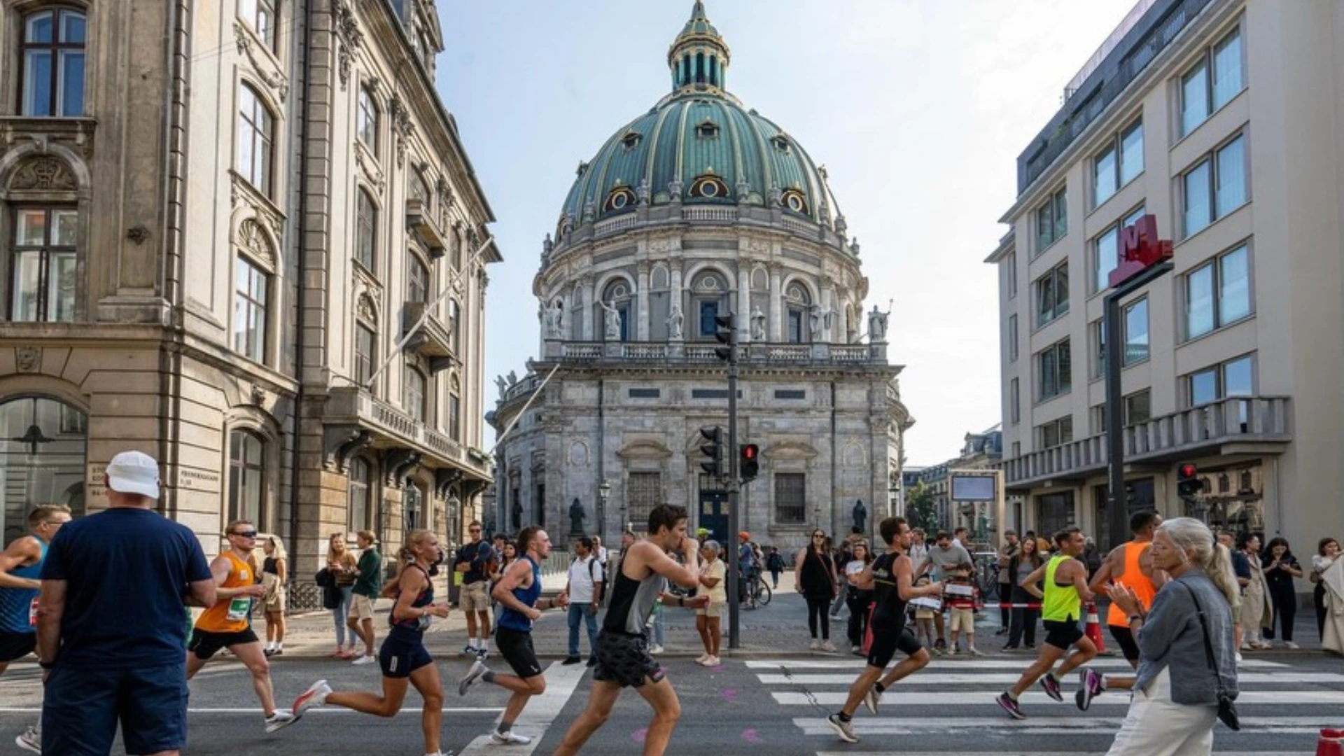 Corredores de maratón en una avenida frente a una iglesia con cúpula